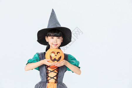 小女孩万圣节女巫打扮拿着南瓜灯背景图片
