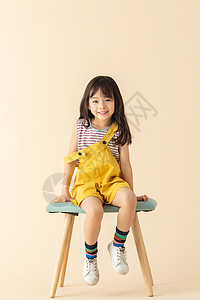 长发小美女可爱小女孩乖巧坐在椅子上背景