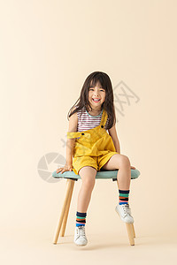 可爱小女孩乖巧坐在椅子上背景图片