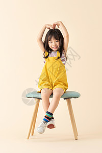 椅子儿童可爱小女孩坐在椅子上比心背景