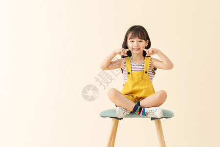 可爱女孩在椅子上笑嘻嘻高清图片