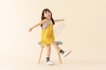 可爱小美女在站在椅子旁边背景