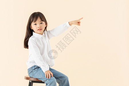小女孩坐在椅子上玩耍图片