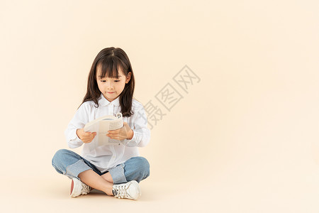 小女孩坐在地上看书培训高清图片素材