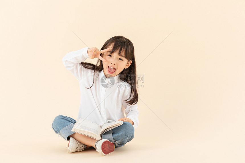 小女孩坐在地上看书图片