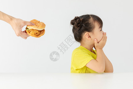 小女孩拒绝吃别人喂的汉堡包背景