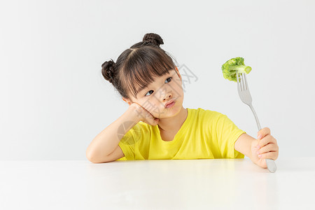 小女孩看着西兰花发呆图片