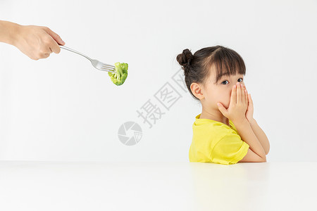 小女孩捂嘴拒绝吃别人喂的食物背景