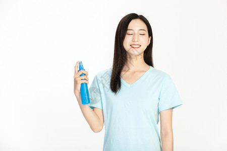 蓝色短袖美女使用花露水背景图片