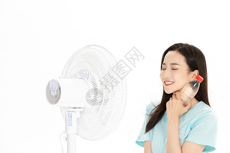 夏日美女拿矿泉水吹风扇图片