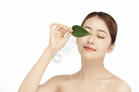 遮眼面容中国人女性拿着一片绿叶背景