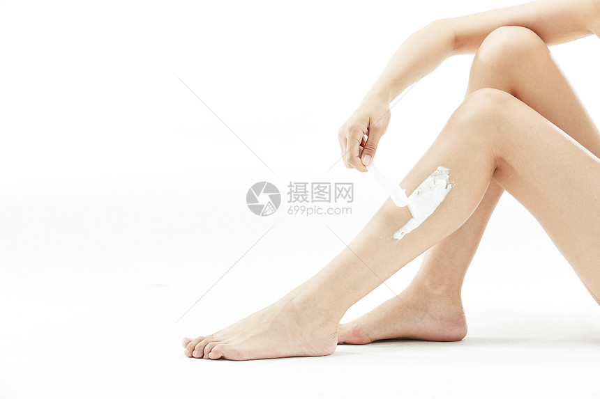 女性腿部涂抹脱毛膏特写图片