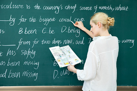 老师讲习题外教老师对着黑板写题背景