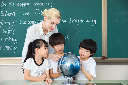 中国人和外国人外教老师带着学生了解地球仪背景