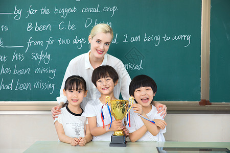 冠军团队老师与儿童在教室与奖杯合影背景