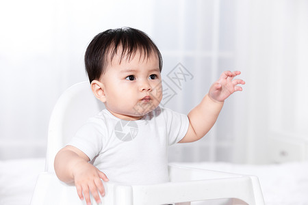 婴儿坐在儿童椅中背景图片