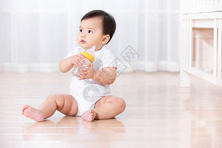 婴儿坐在地板上玩耍背景图片