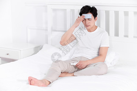 男子发烧感冒靠在床上休息正侧面图片