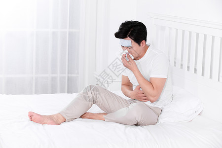 男子发烧感冒靠在床上休息高清图片