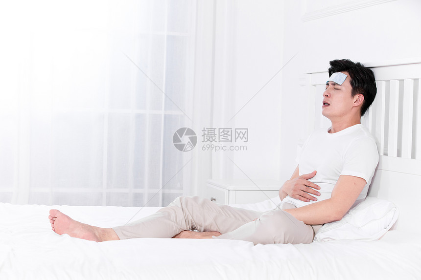 男子发烧感冒靠在床上休息图片