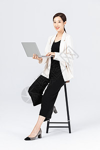 坐在高脚椅上的商务女性看笔记本电脑高清图片