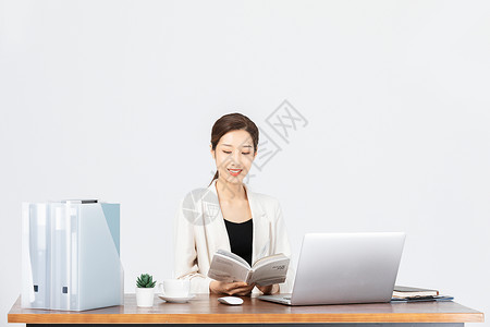 坐在办公桌前看文件的商务女性高清图片
