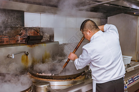 厨师在厨房翻炒食物【媒体用图】背景