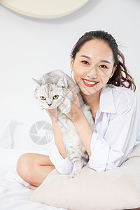 年轻美女和宠物猫在家嬉戏背景图片