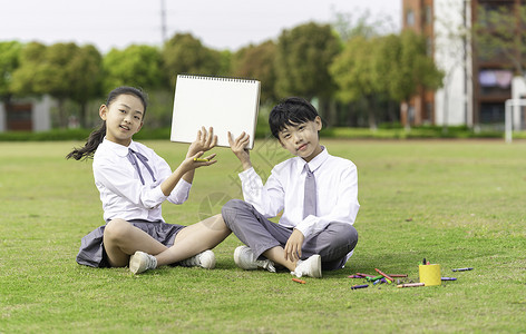 学生坐在草地上拿着画板高清图片