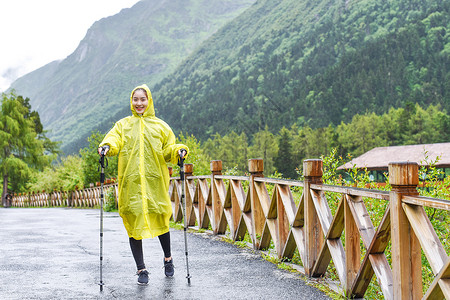 雨中徒步徒步穿雨衣的女生背景