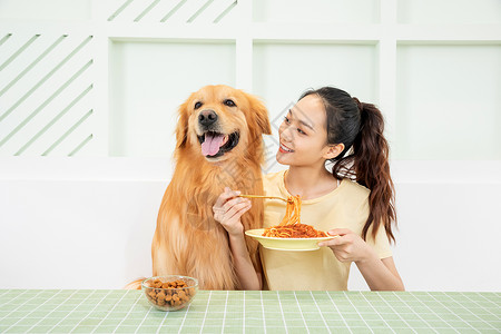 美女主人和宠物狗一起吃饭高清图片