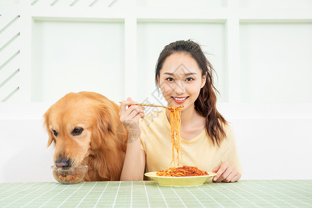 美女主人和宠物狗一起吃饭高清图片