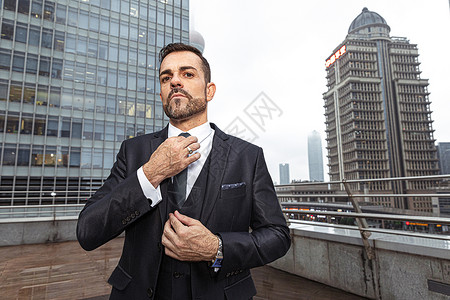 外国商务男模整理领带背景图片
