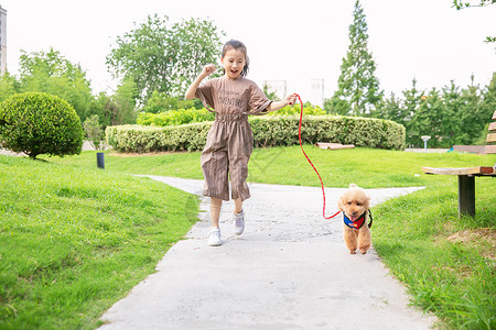 小女孩跳绳小女孩户外遛狗和狗玩耍背景