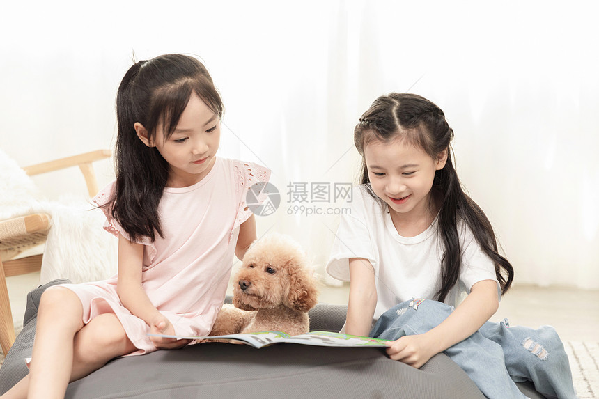小女孩们和狗狗一起看书图片
