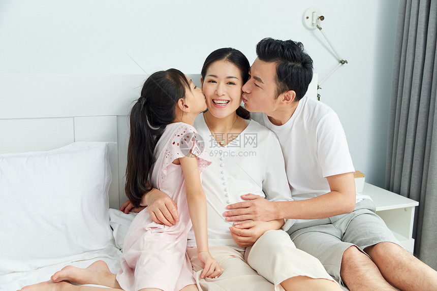 小女孩和爸爸亲吻怀孕的妈妈图片