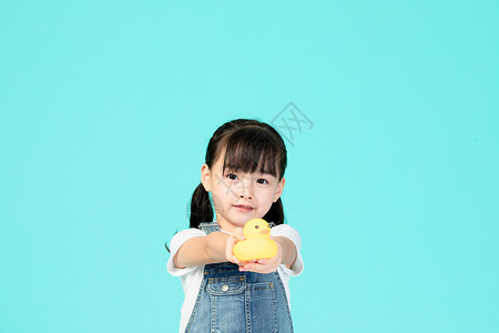 小女孩拿着小黄鸭背景图片