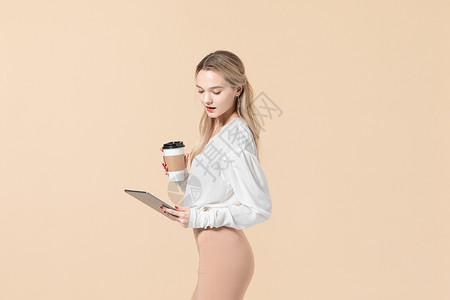 拿着平板电脑和咖啡杯的外国女模特背景图片