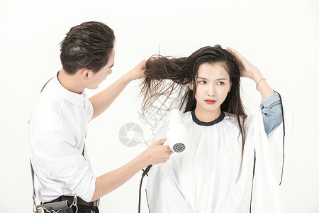 理发师用吹风机给顾客吹干头发图片