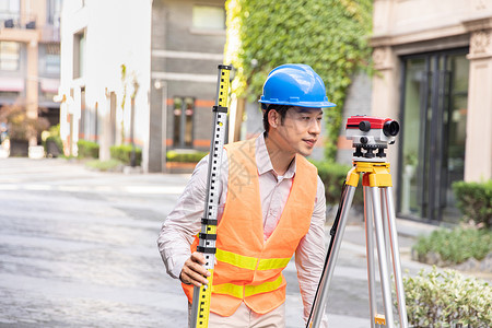 测绘尺户外工人拿着水准仪和水平尺测量背景