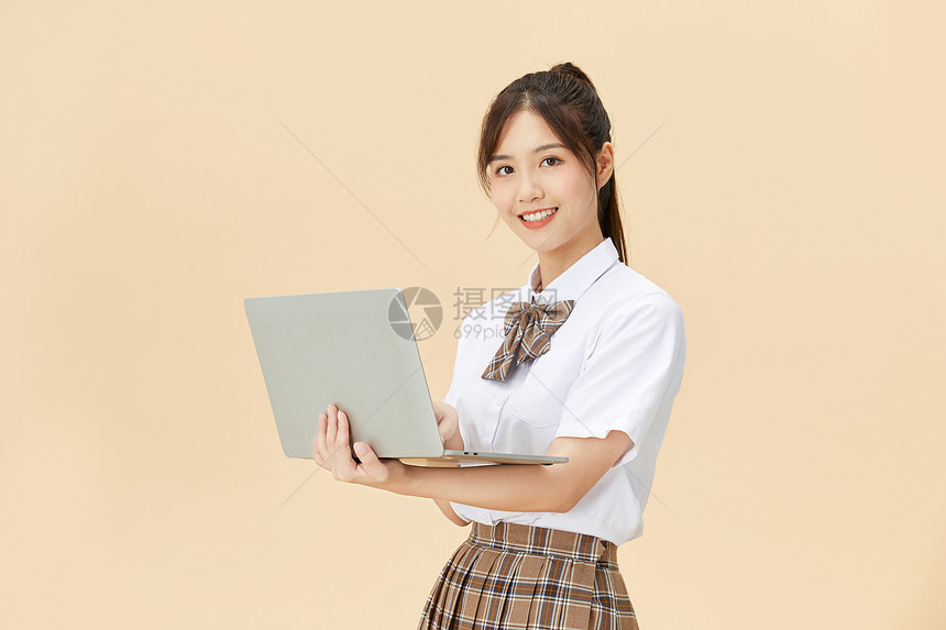 拿着笔记本电脑的女学生图片