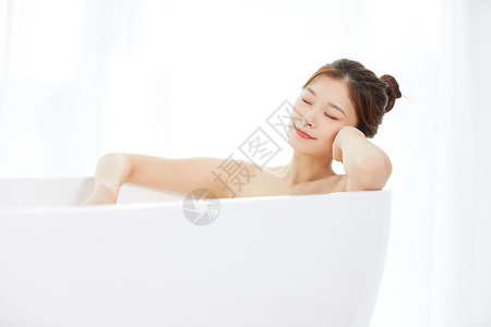 女性躺在浴缸里洗泡泡浴高清图片