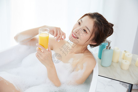 美女躺在浴缸洗泡泡浴喝果汁图片
