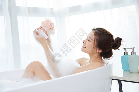 年轻女性在浴缸洗澡图片