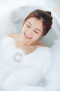 女性躺在浴缸里洗泡泡浴高清图片