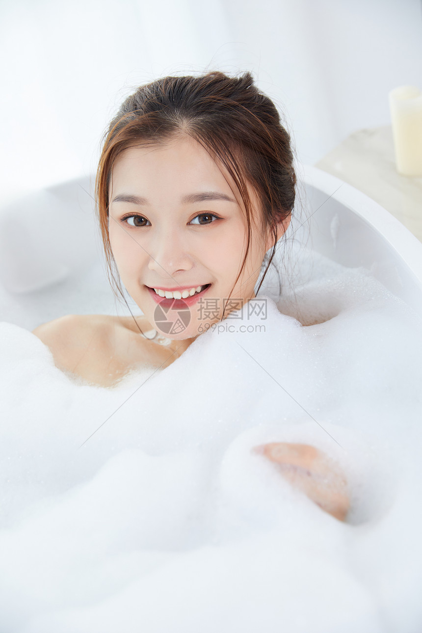 女性躺在浴缸里洗泡泡浴图片
