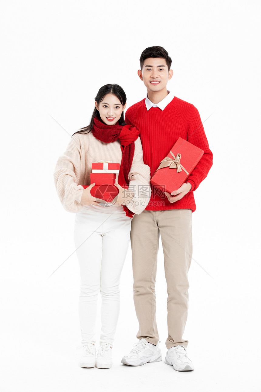年轻夫妻过年拿着礼物盒图片