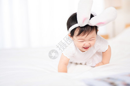 兔宝宝板材婴儿在床上玩耍背景
