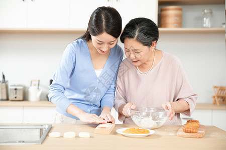 妈妈和女儿一起做月饼高清图片