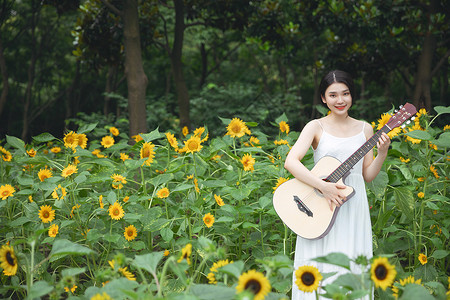 向日葵中拿着吉他的少女背景